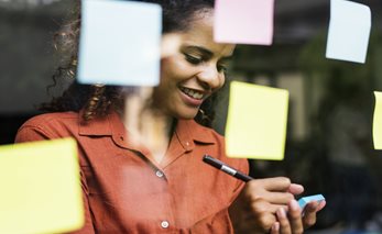 Women writing and sticking up post-it notes thumbnail