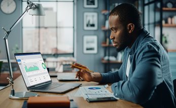 Man looking at statistics on laptop thumbnail